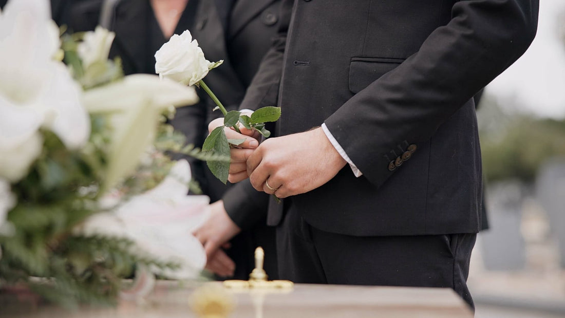 Funeral Etiquette in NZ: Person in Suit Holding White Flower