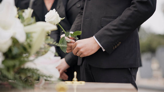 Funeral Etiquette in NZ: Person in Suit Holding White Flower