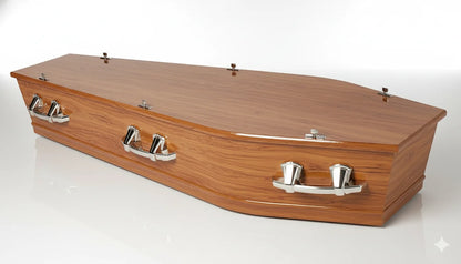 A high-quality product shot of an elegant wooden casket, presented in a three-quarter view against a clean, pure white studio background with a subtle reflective surface. The lighting is bright, soft, and evenly diffused, highlighting the casket's polished finish and detailed silver-toned handles, with minimal shadows for a professional and clear presentation