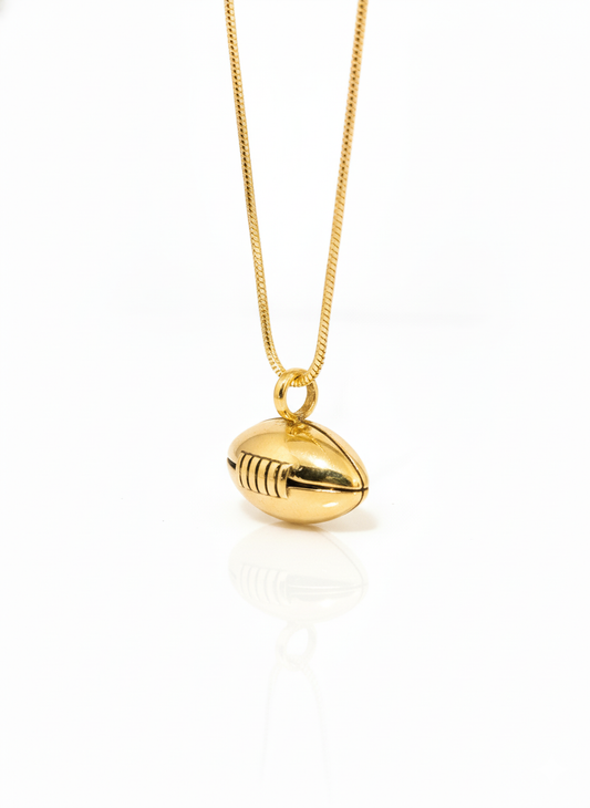 Gold football-shaped pendant on a chain against a white background