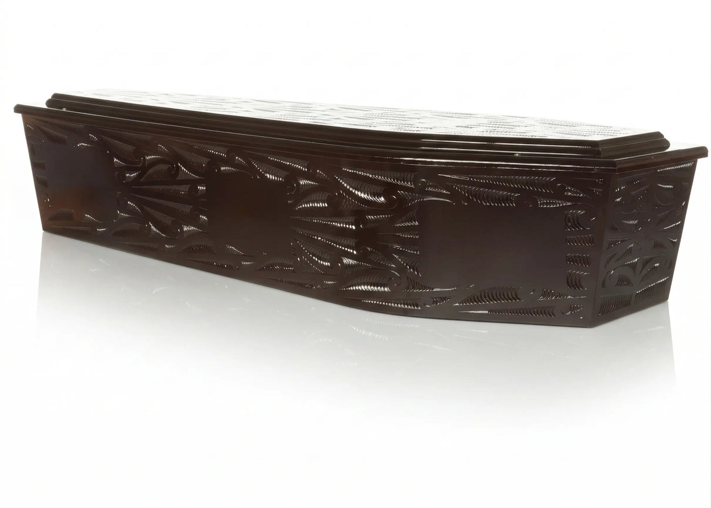 premium dark wood burial urn featuring intricate, traditional Māori-inspired carvings. The urn has a high-gloss polished finish that catches the light, showcasing the deep textures of the artisan woodwork. It is presented on a clean, reflective white studio surface with soft, even lighting to highlight the craftsmanship and elegant silhouette of this memorial piece