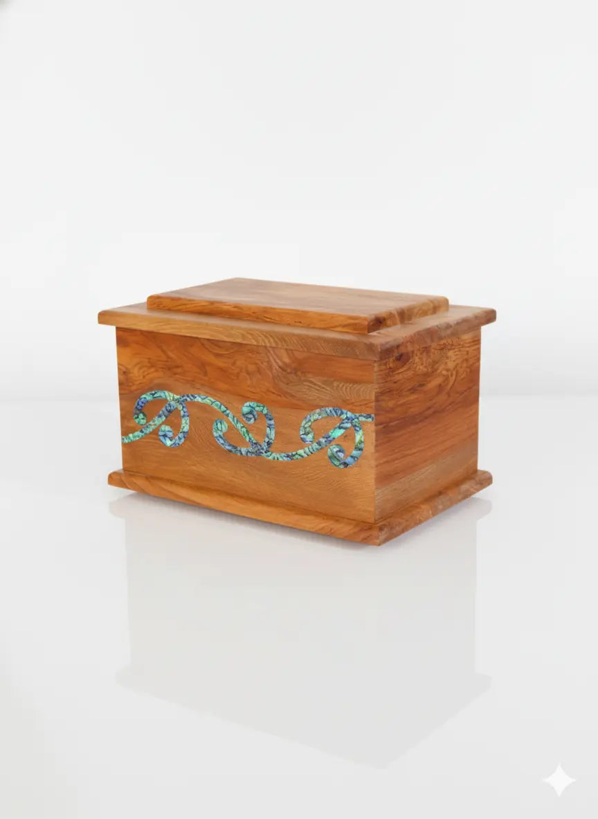 Handcrafted cremation urn made from recycled native rimu timber with an iridescent paua kowhaiwhai design inlay